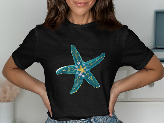Black t-shirt with a blue starfish design adorned with small flowers.