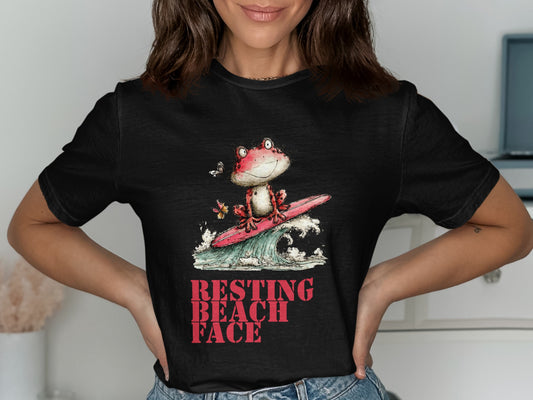 Black t-shirt with graphic of frog surfing a wave, text "RESTING BEACH FACE".