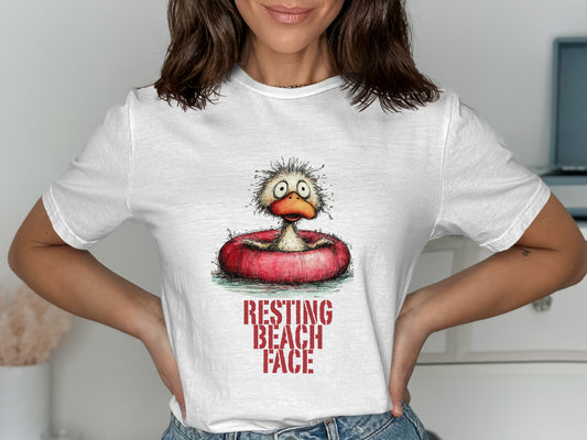 White t-shirt with a cartoon duck in an inner tube, text reads "RESTING BEACH FACE".