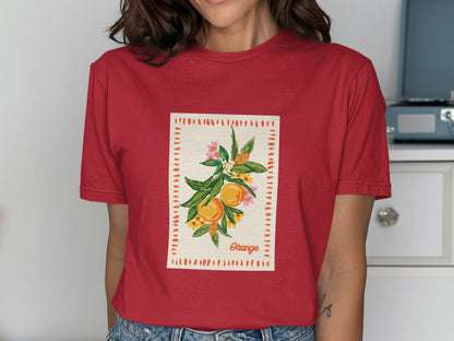 Red t-shirt featuring a framed illustration of oranges and flowers with "Orange" text.