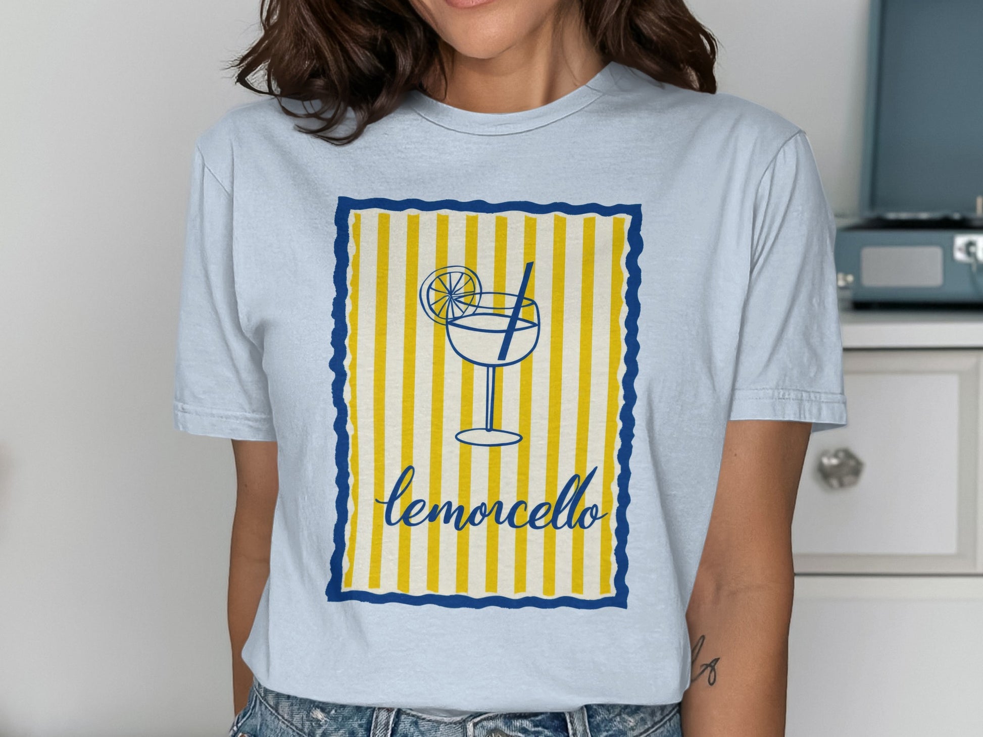 Light blue t-shirt featuring a limoncello glass and drink with straw.