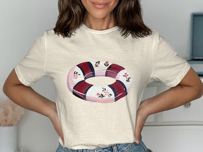 Cream t-shirt with a round life preserver graphic featuring red stripes and floral accents.