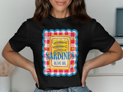 Black t-shirt with a graphic of three sardines in olive oil on a red and white checkered background.
