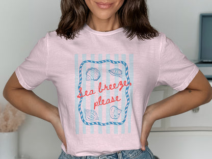 Pink t-shirt with "Sea breeze, please" text and seashells.