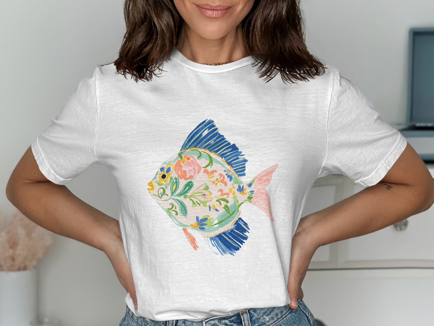 White t-shirt with a colorful floral fish illustration.