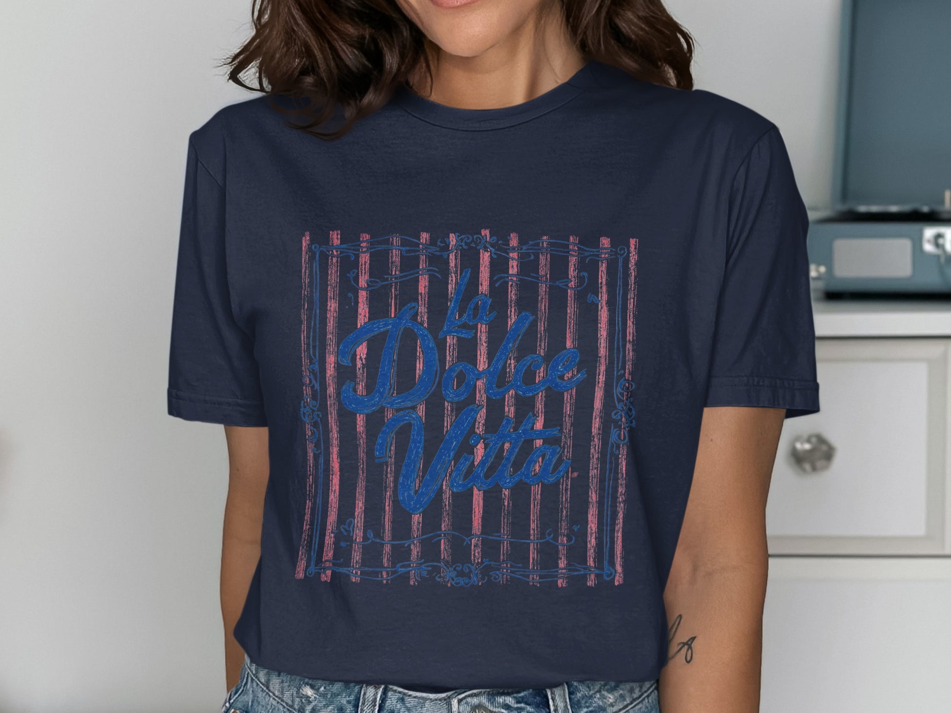 Navy t-shirt with "La Dolce Vita" text in blue over red stripes.
