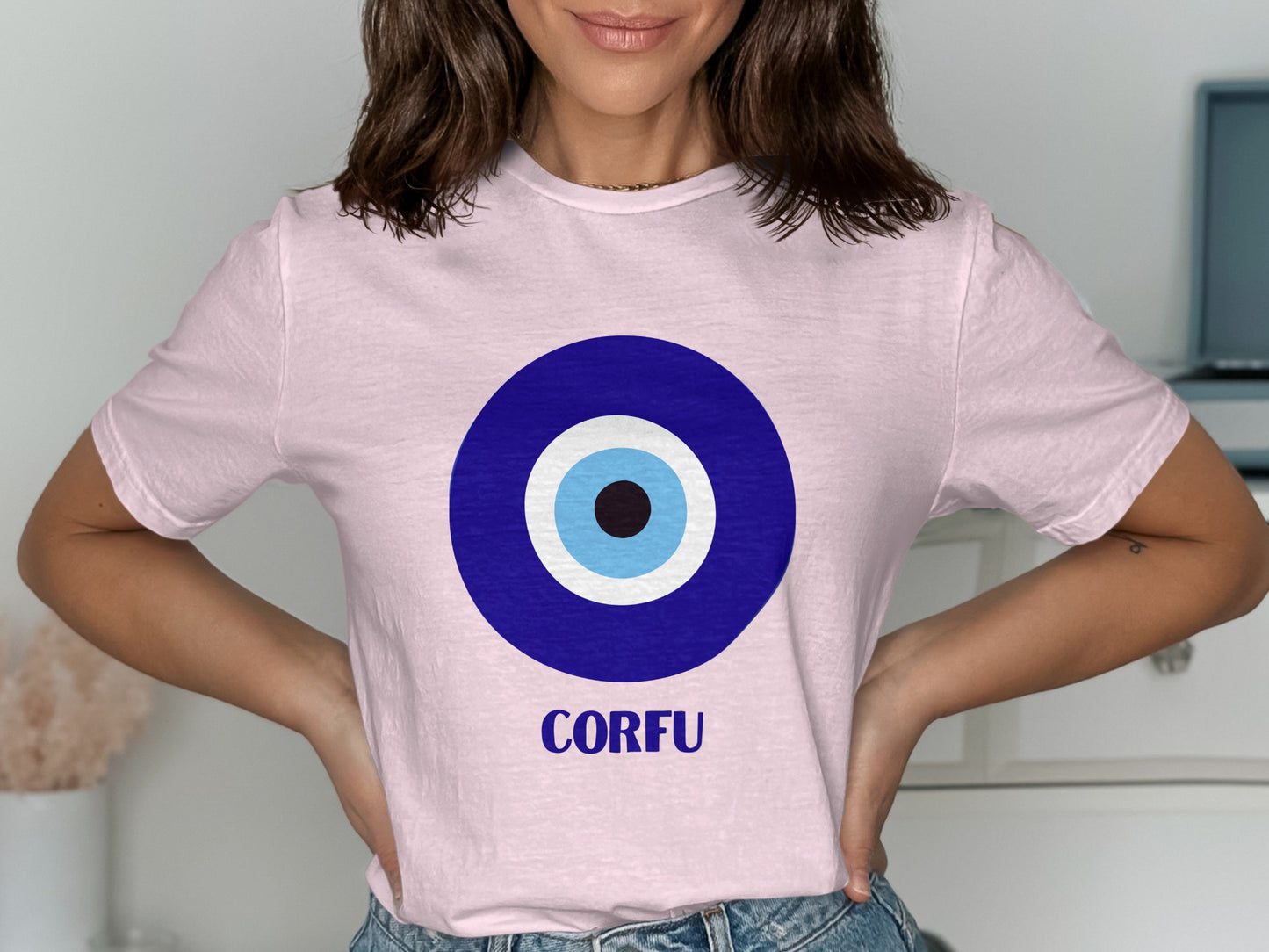 Pink t-shirt with a blue and white evil eye symbol and "CORFU" text.