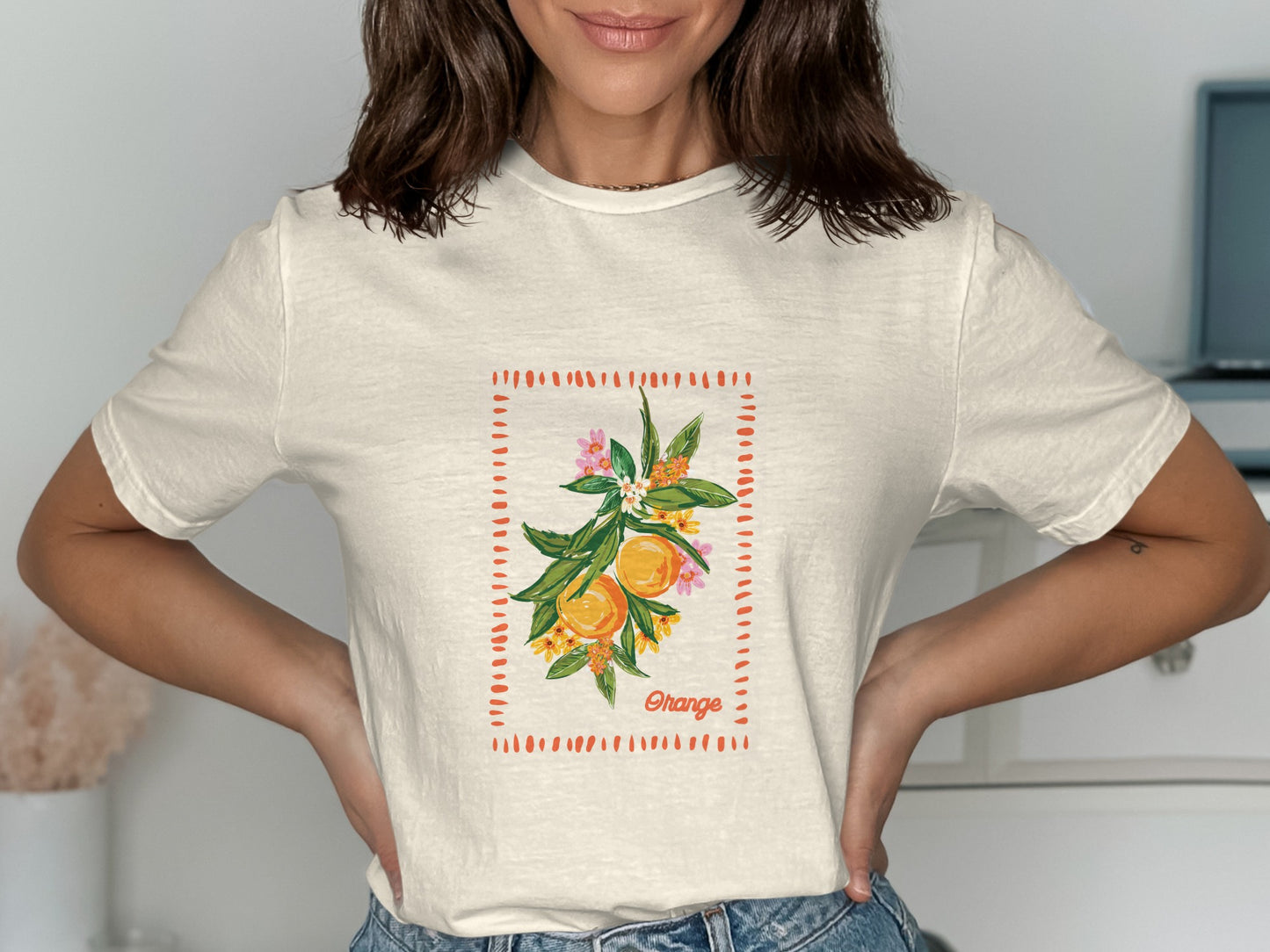 Cream t-shirt with a watercolor illustration of oranges on a branch.