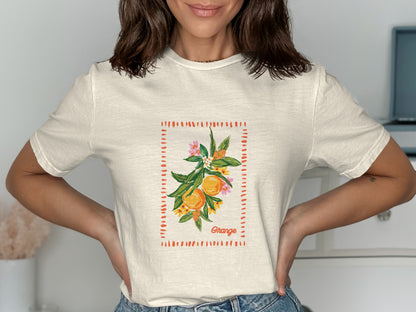 Cream t-shirt with a watercolor illustration of oranges on a branch.