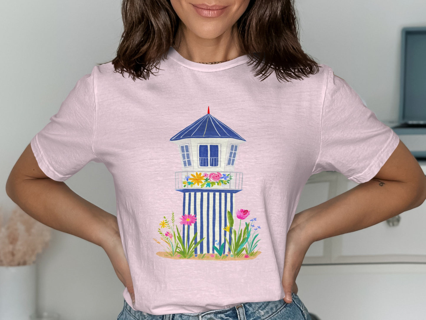 Pink t-shirt with a blue and white lifeguard tower graphic and floral accents.
