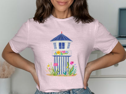 Pink t-shirt with a blue and white lifeguard tower graphic and floral accents.
