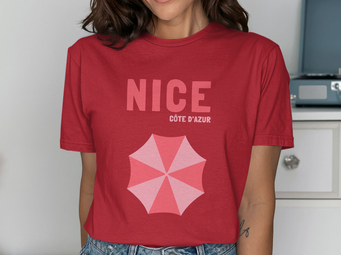 Red t-shirt with "NICE CÔTE D'AZUR" and an open pink umbrella graphic.
