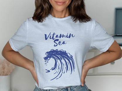 White t-shirt with "Vitamin Sea" text and blue wave graphic.