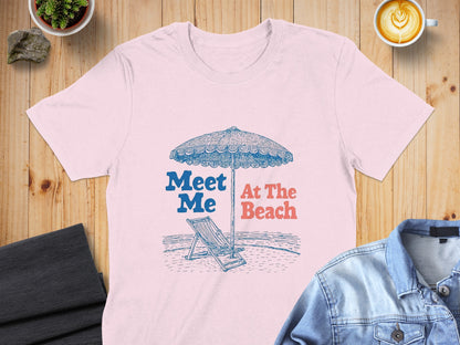 Pink t-shirt with "Meet Me At The Beach" text and beach scene graphic.