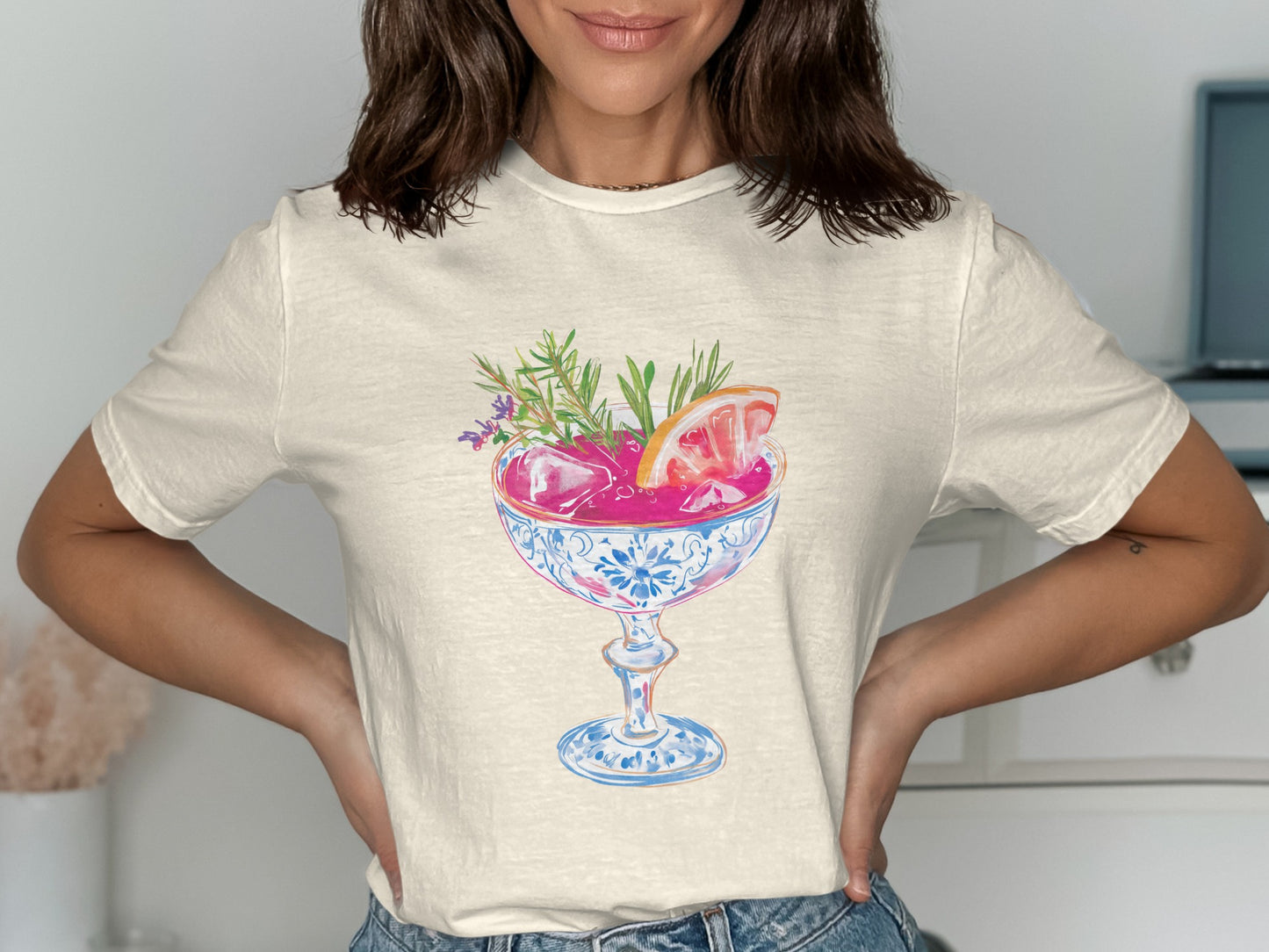 Cream t-shirt with colorful cocktail illustration featuring fruit and herbs.