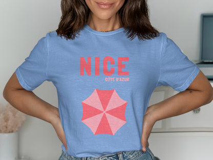 Light blue t-shirt with "NICE CÔTE D'AZUR" and a pink umbrella graphic.