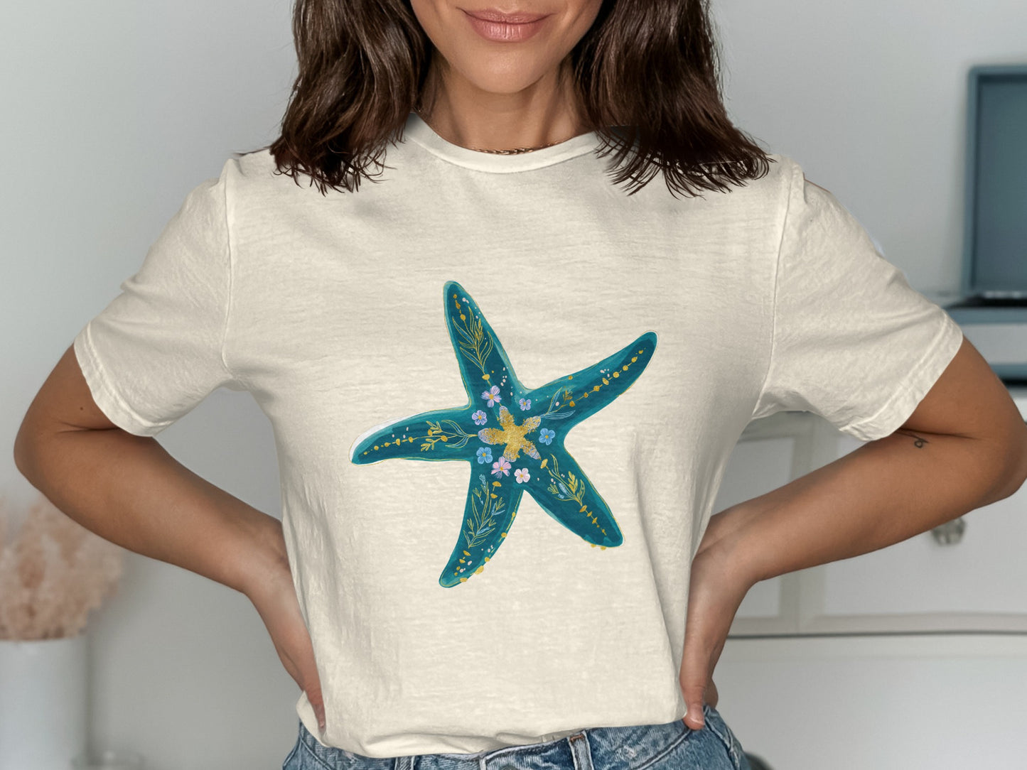 Cream t-shirt with a blue starfish design featuring floral accents.