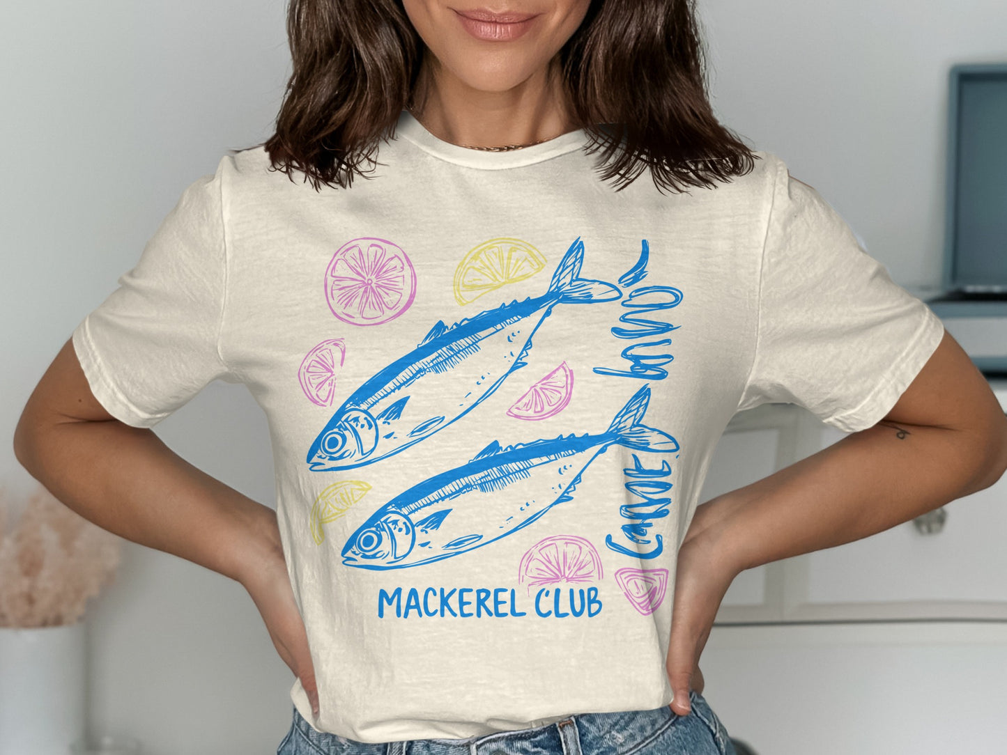 Cream t-shirt with blue mackerel and citrus slices, "Mackerel Club" text.