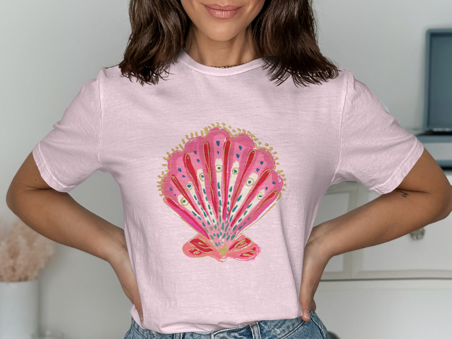 Pink t-shirt with a watercolor illustration of a pink seashell.