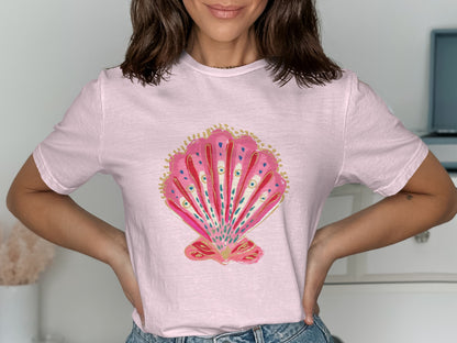 Pink t-shirt with a watercolor illustration of a pink seashell.