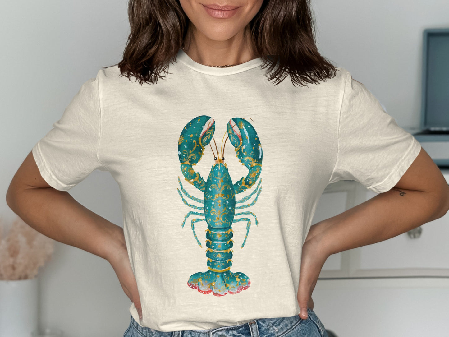 Cream t-shirt with teal lobster graphic featuring ornate gold details.