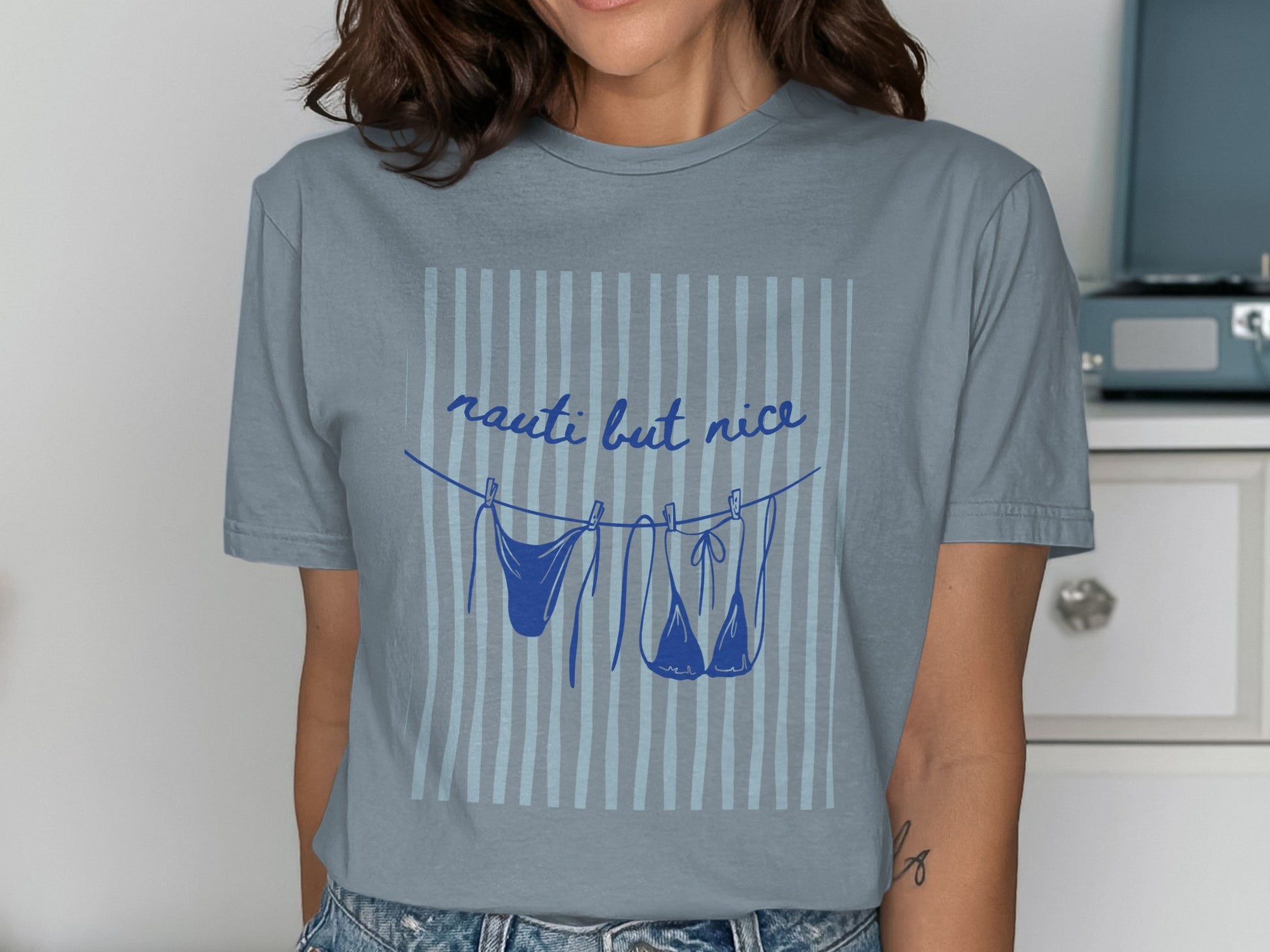 Blue t-shirt with "nauti but nice" text and lingerie hanging on a clothesline.
