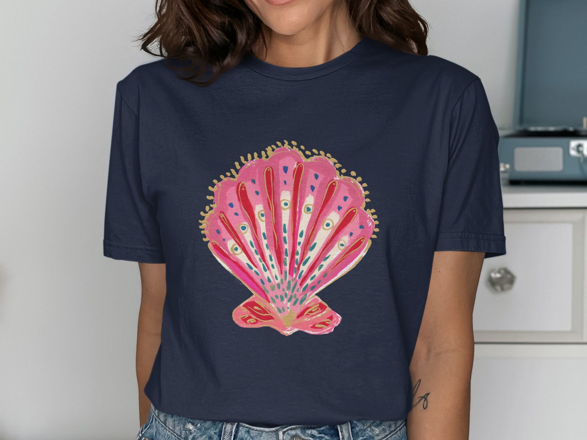 Navy t-shirt with a pink and gold painted seashell design.