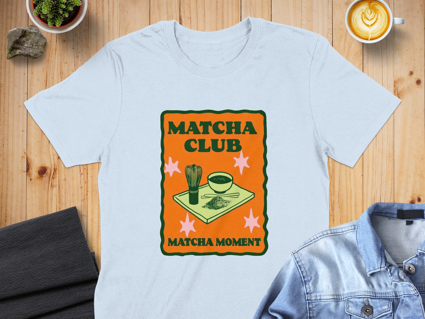 Light blue t-shirt with "Matcha Club Matcha Moment" graphic and matcha tea set.