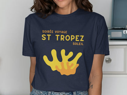 Navy t-shirt with yellow "SOIRÉE VOYAGE ST TROPEZ SOLEIL" text and abstract art.