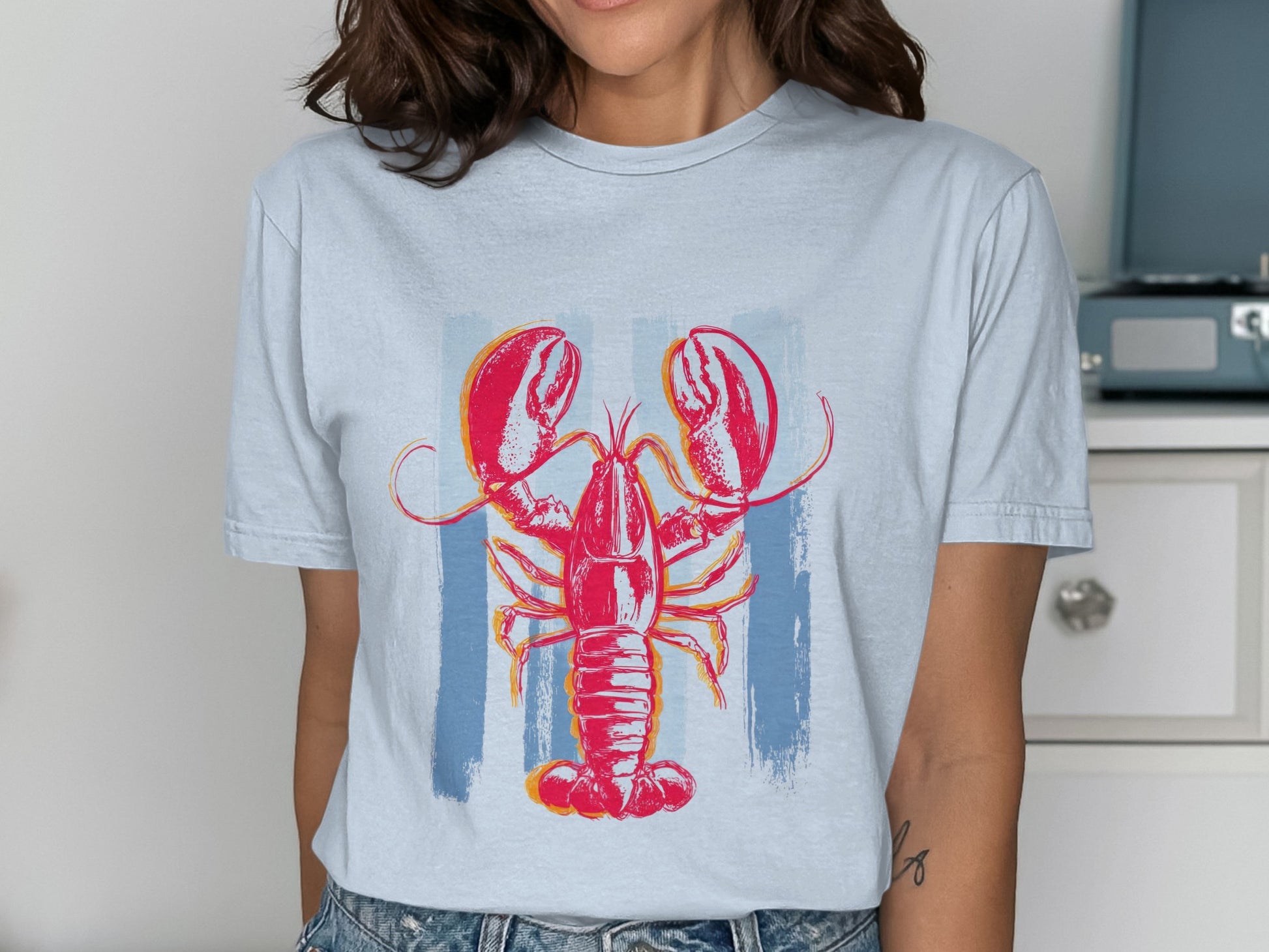 Red lobster graphic on a light blue t-shirt with vertical blue stripes.