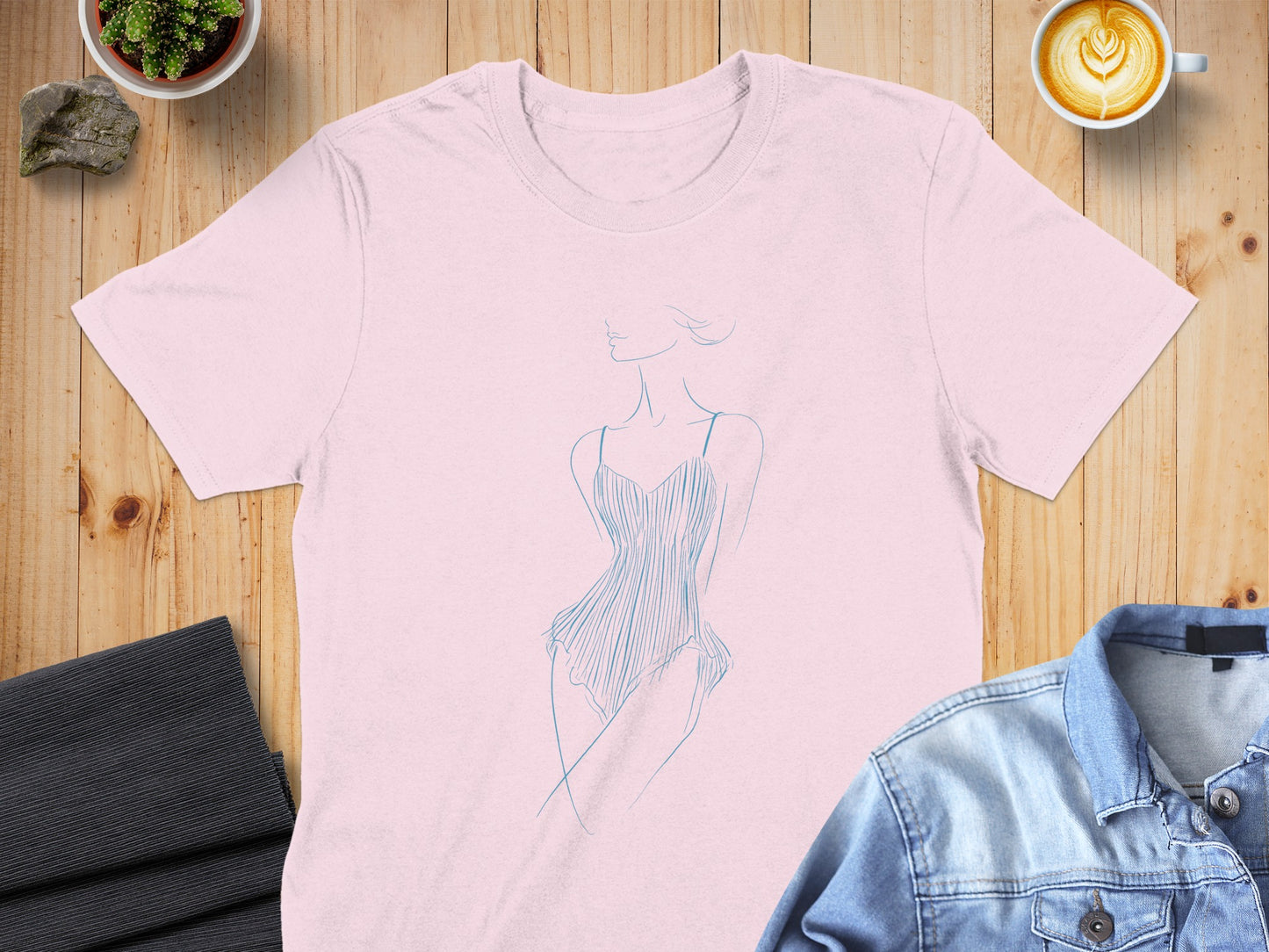 Pink t-shirt with a blue line drawing of a woman in a leotard.