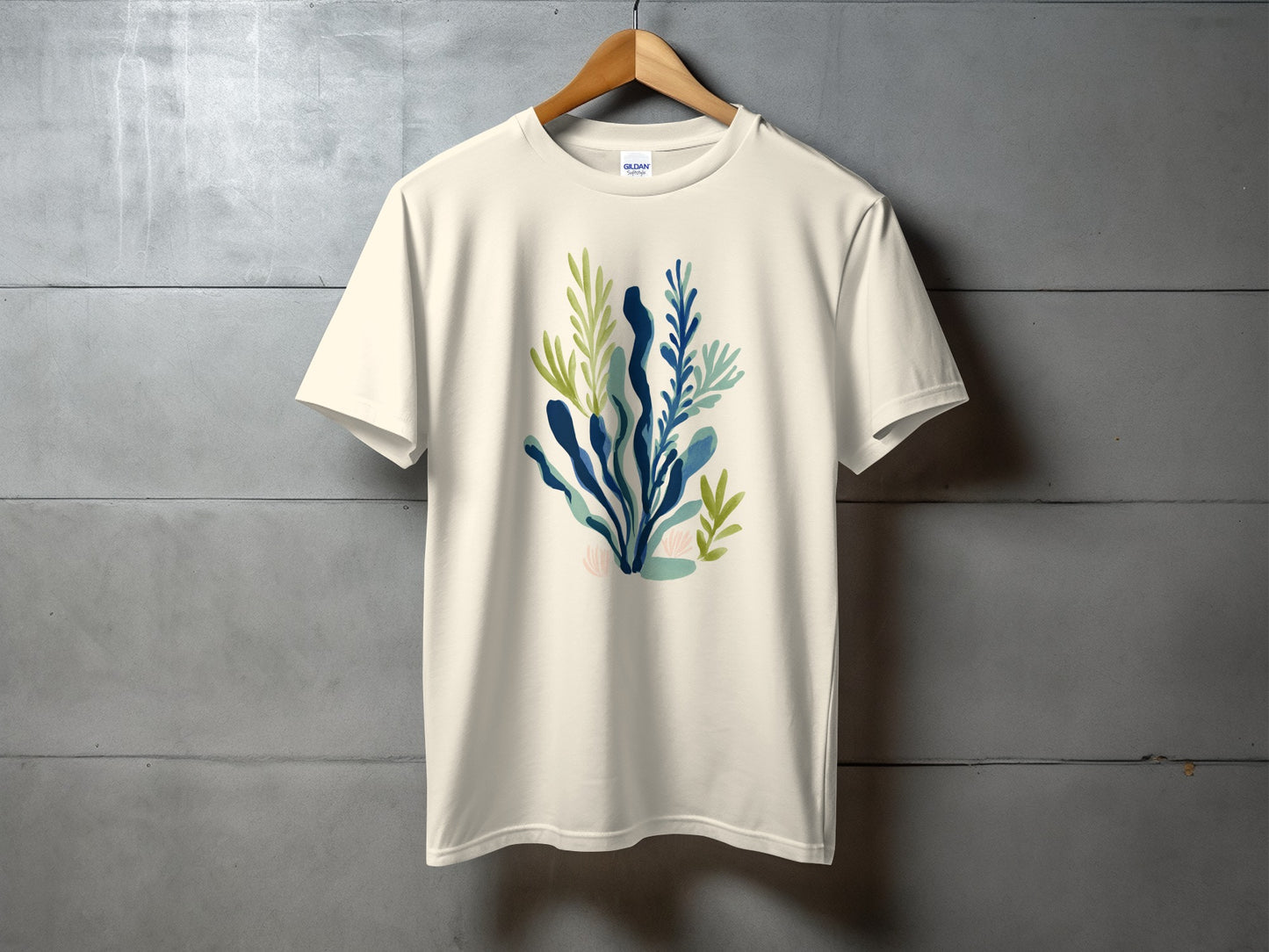 Cream t-shirt with watercolor abstract blue and green botanical illustration.