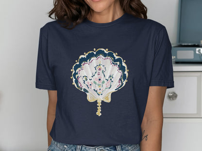 Navy t-shirt with a decorative seashell design featuring gold and floral accents.