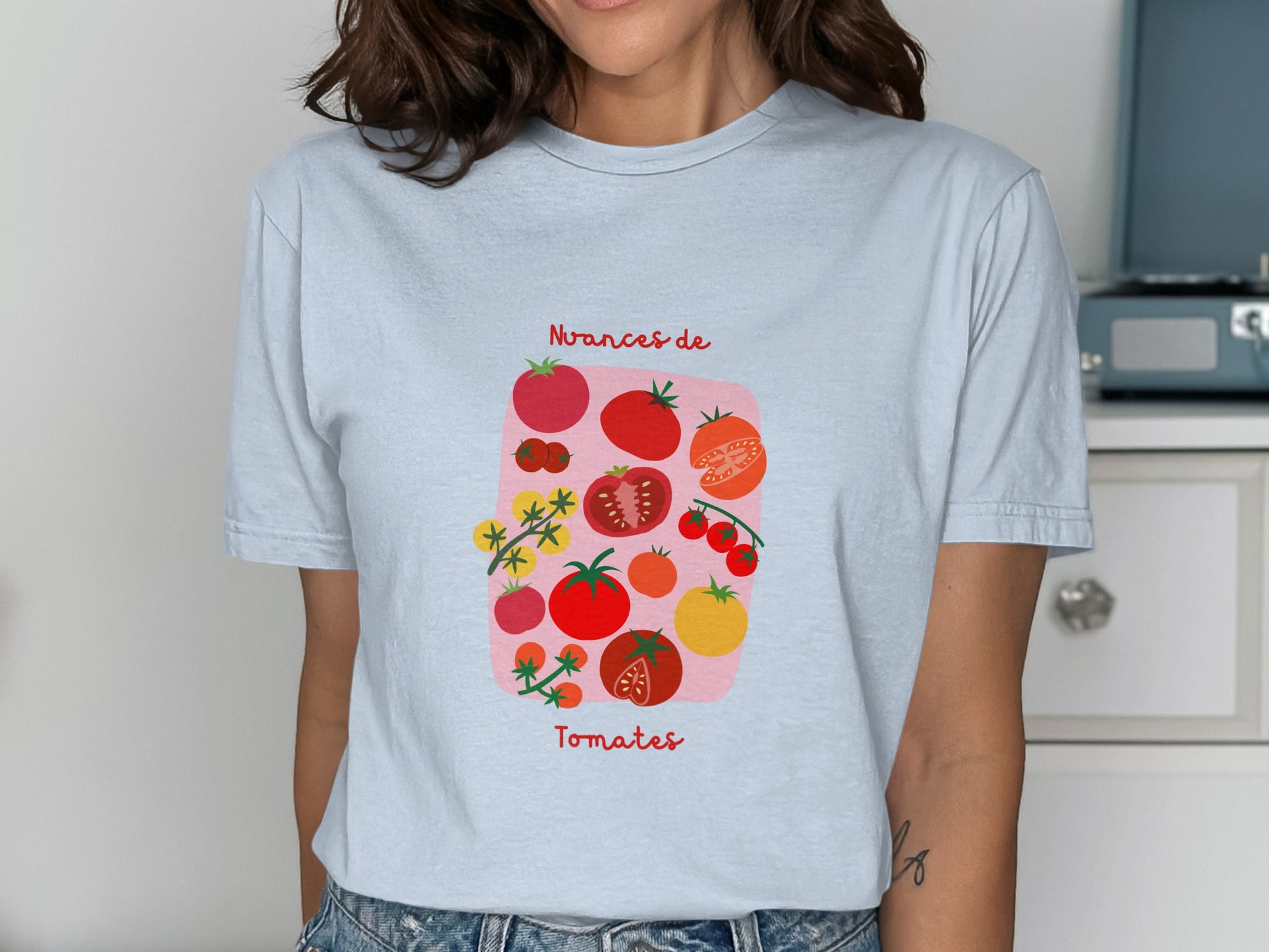 Light blue t-shirt with graphic of various tomatoes and text "Avances de Tomates".