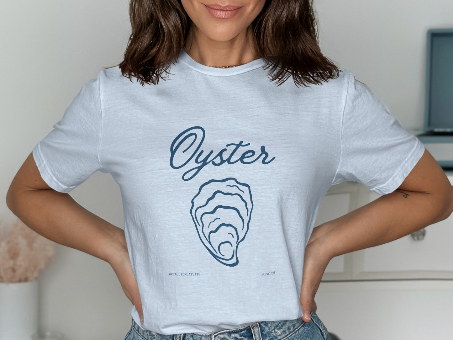 White t-shirt with blue text: "Oyster" above an oyster shell illustration and "#WEALLTREA TSITE".