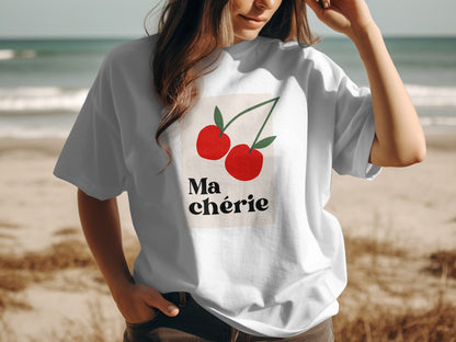 White t-shirt with two red cherries and "Ma chérie" text on a beach.
