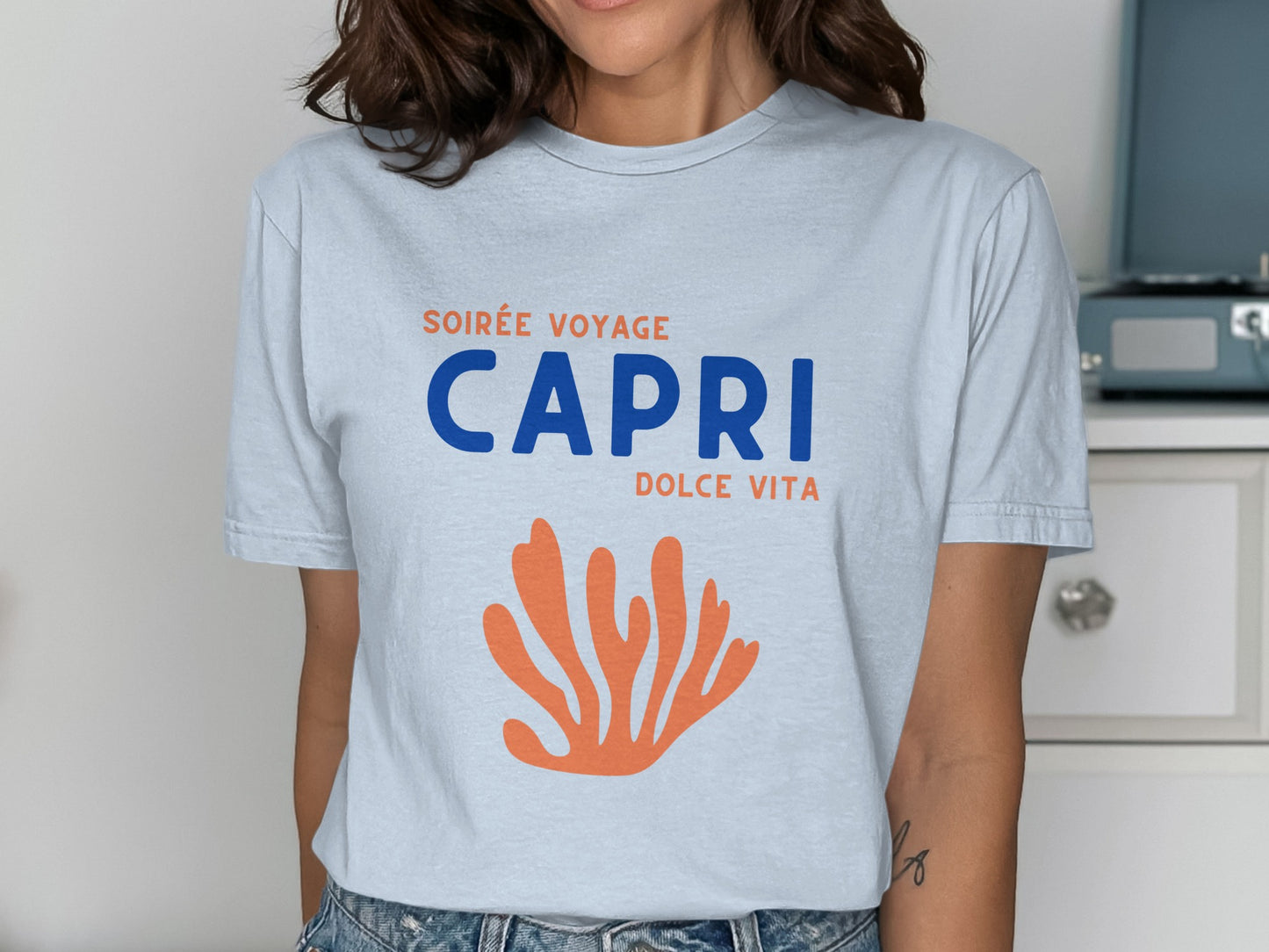 Blue and orange text "Soirée Voyage Capri Dolce Vita" on a t-shirt.
