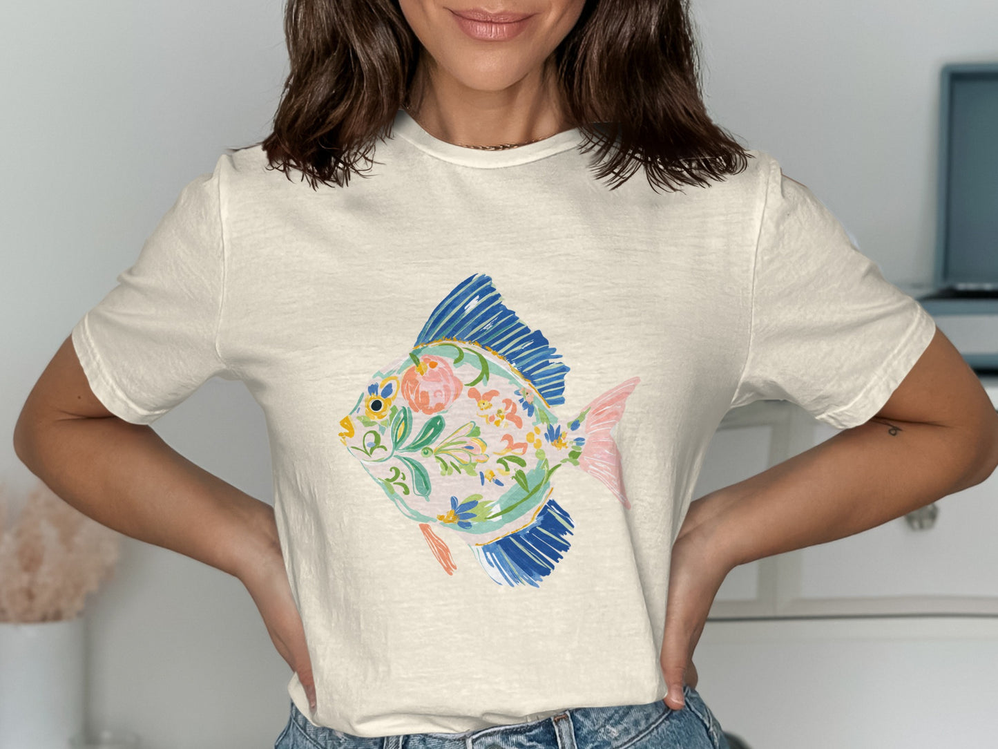 Cream t-shirt with colorful painted fish design.