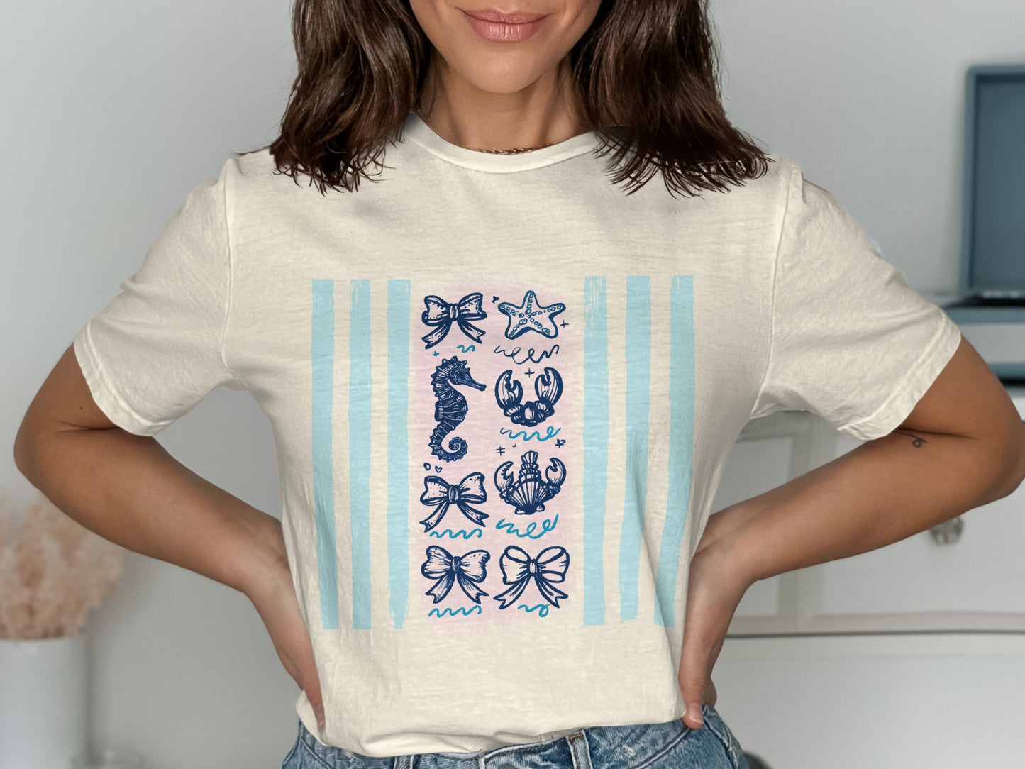 Cream t-shirt with blue stripes and a grid of eight nautical illustrations.