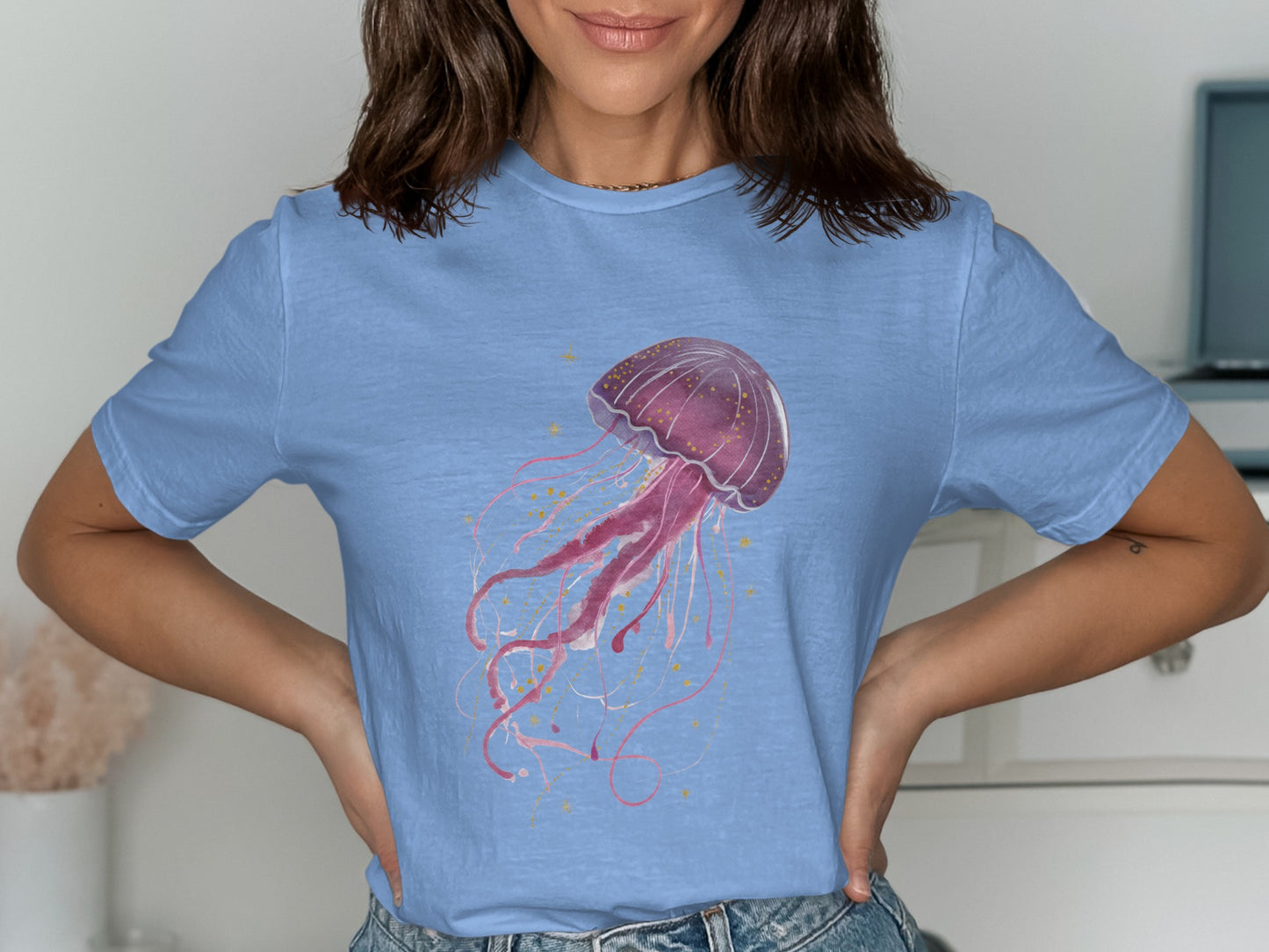 Light blue t-shirt with a pink watercolor jellyfish graphic and gold speckles.