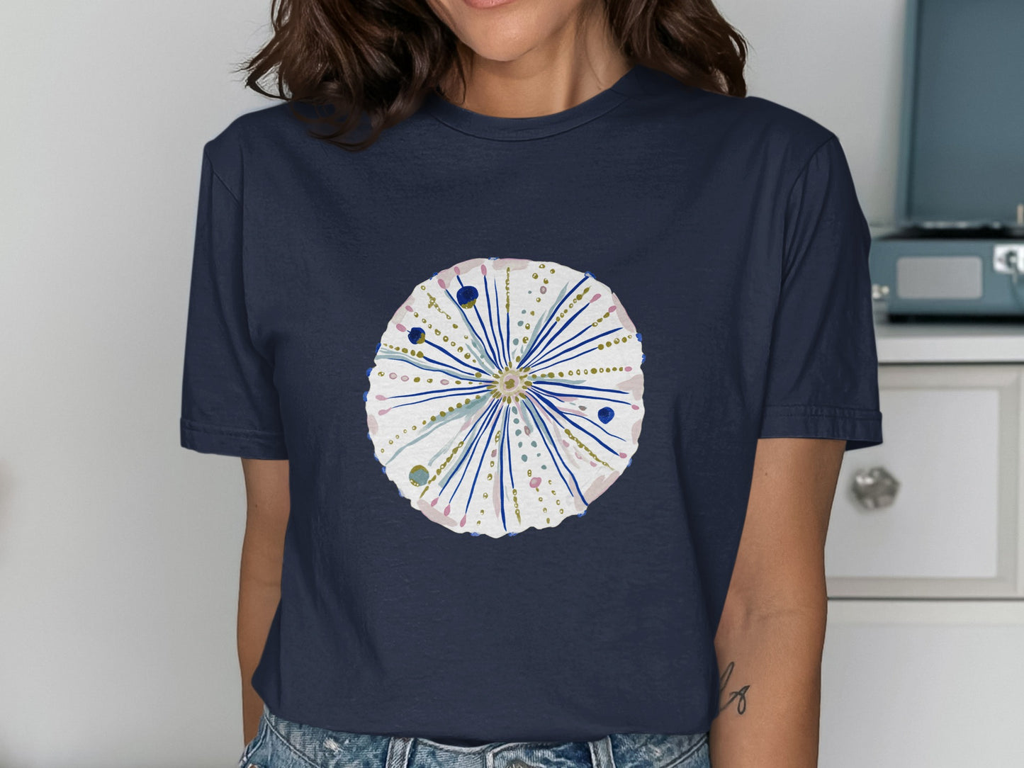 Dark navy t-shirt with a watercolor sea urchin design featuring pink and gold accents.