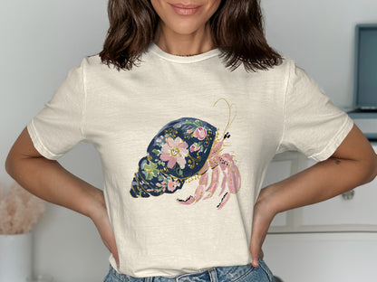Cream t-shirt with a watercolor hermit crab illustration on a dark blue shell.