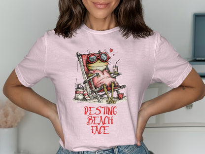 Pink t-shirt with graphic of frog in beach chair, "RESTING BEACH FACE" text.