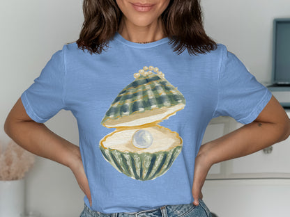 Light blue t-shirt with watercolor graphic of an open oyster revealing a pearl and smaller pearls.