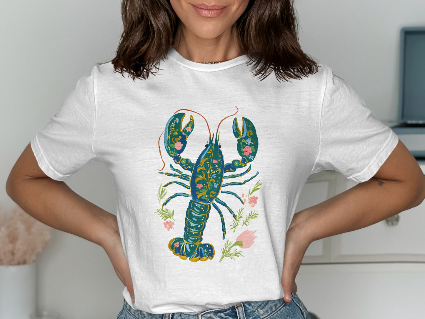 White t-shirt featuring a blue, ornate lobster with floral accents.