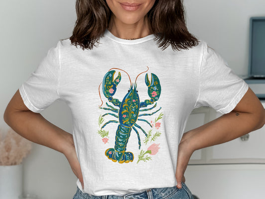 White t-shirt featuring a blue, ornate lobster with floral accents.