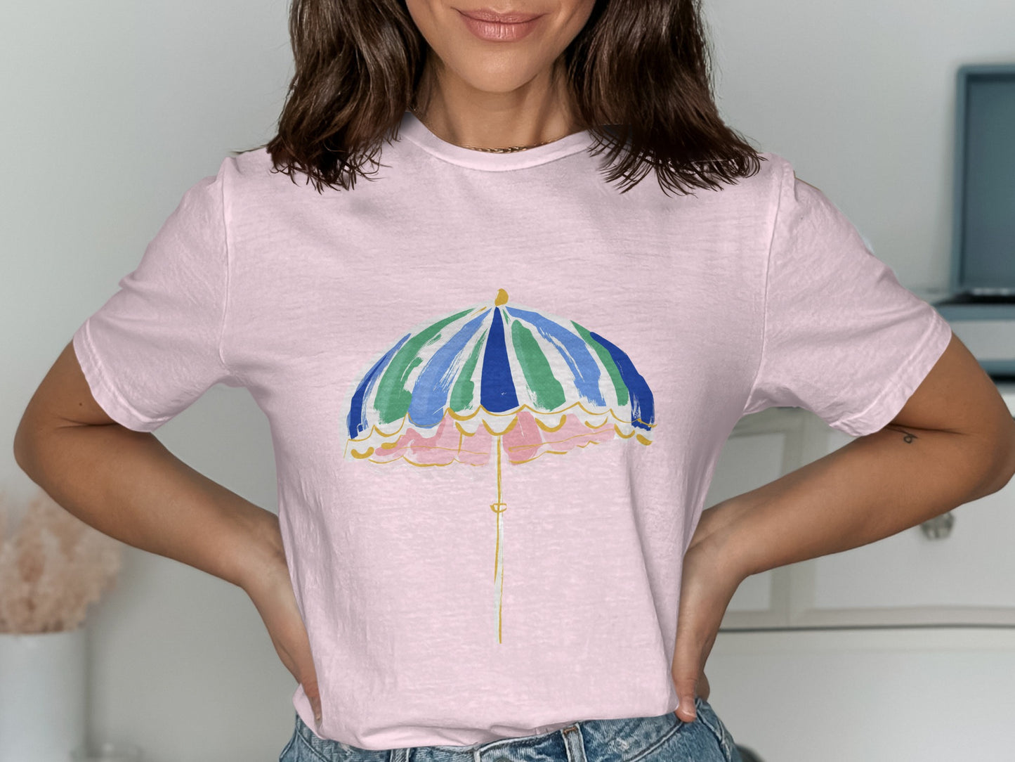 Pink t-shirt with a colorful striped umbrella graphic.