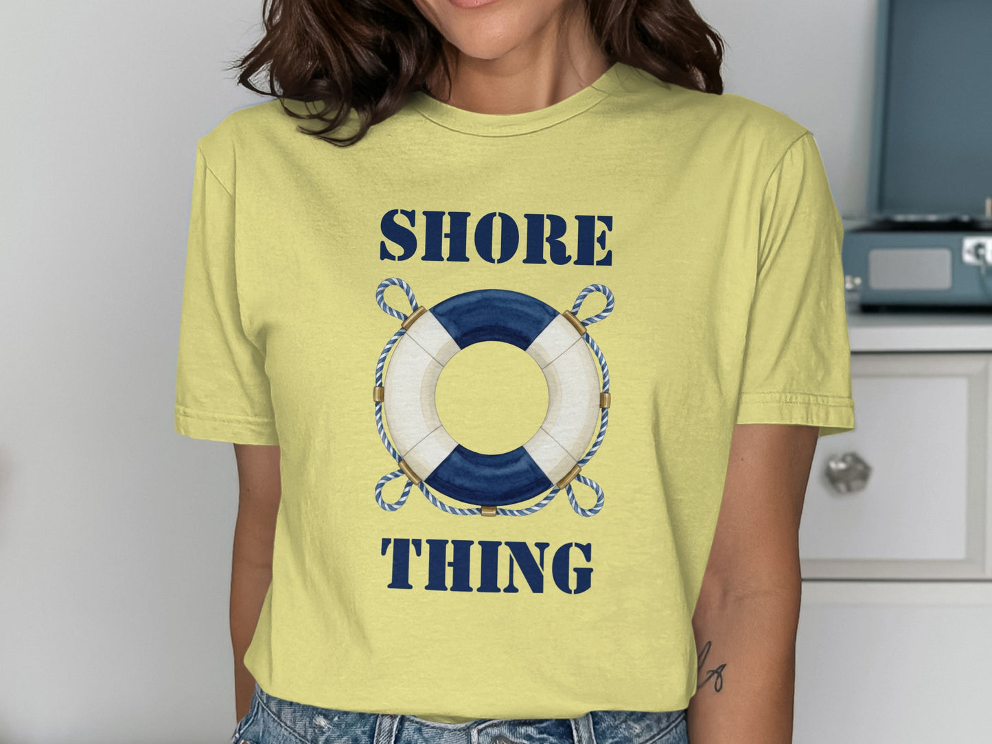 Yellow t-shirt with blue and white life preserver and "SHORE THING" text.