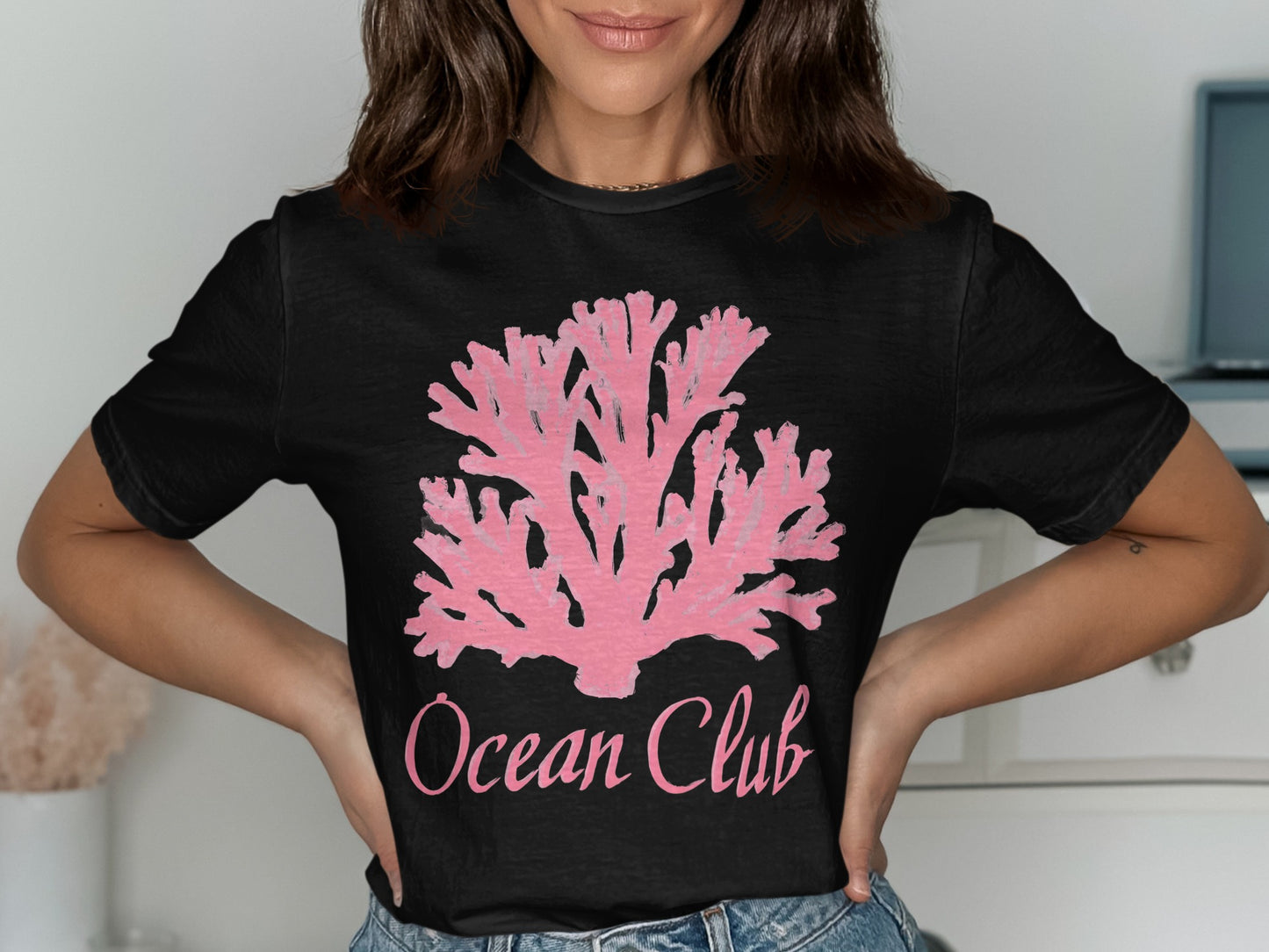 Black t-shirt with a pink coral design and "Ocean Club" text.