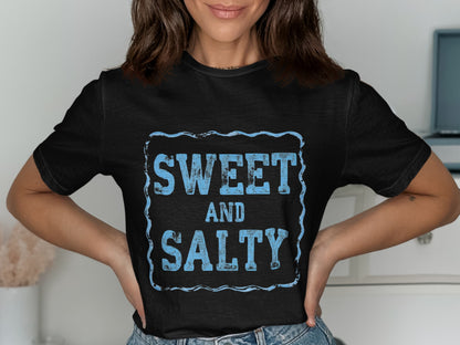 Black t-shirt with "SWEET AND SALTY" in distressed blue text within a blue border.